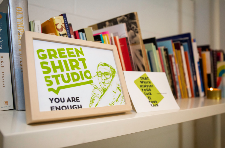 Bookcase with picture of Green Shirt Studio logo focused
